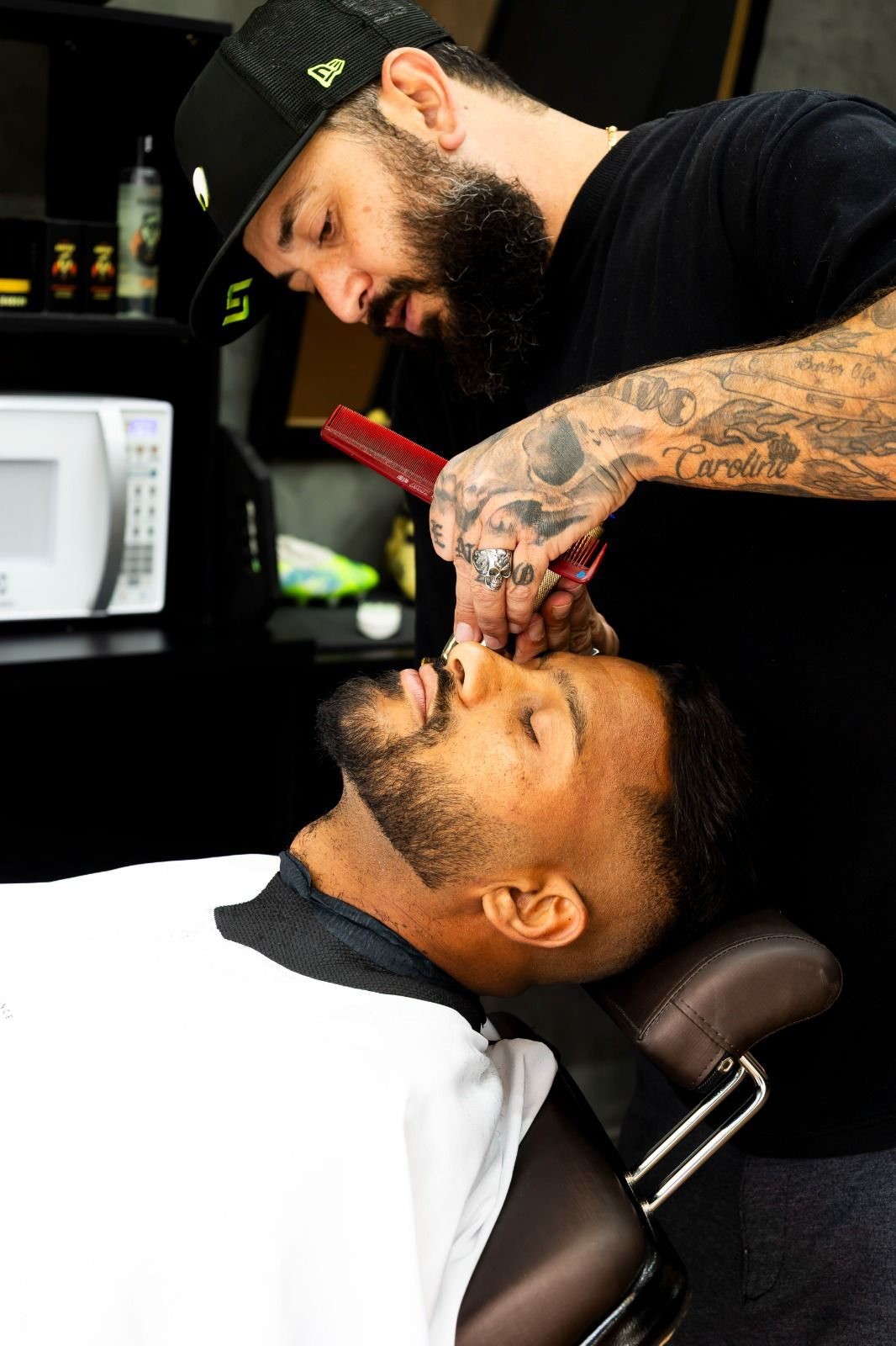 Barbeiro Raphael Malfara com cliente atendido em Monte Aprazível